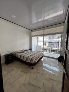 a bedroom with a bed and a large window at EDIFICIO BETEL in Salvador Mazza