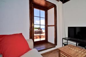 プンタゴルダにあるCasa Demetria La Palmaの窓、ソファ、テレビ付きのリビングルームが備わります。