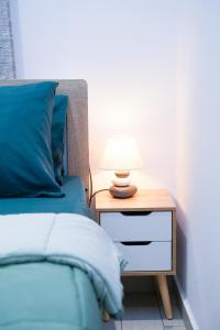 a bed with a night stand with a lamp on it at SunStone Apartment in Fira