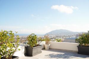 balcón con plantas y vistas a la ciudad en SunStone Apartment en Fira