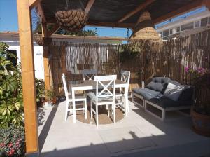 eine Terrasse mit einem Tisch, Stühlen und einem Sofa in der Unterkunft Spirit of Costa Calma in Costa Calma
