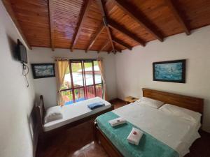 1 dormitorio con 2 camas y ventana en El Gran Mirador, en Buenavista