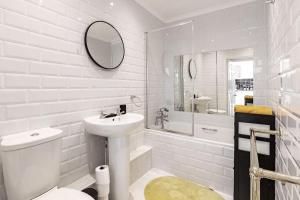 a white bathroom with a sink and a toilet at One bedroom duplex apartment located in cowley. in Oxford