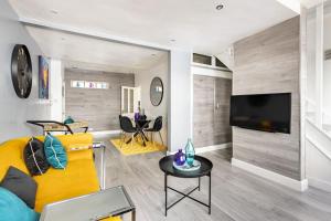 een woonkamer met een gele bank en een tv bij One bedroom duplex apartment located in cowley. in Oxford