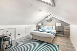 a white bedroom with a bed and a rug at One bedroom duplex apartment located in cowley. in Oxford