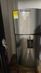 a stainless steel refrigerator in a corner of a room at EL EDÉN in Puerto Triunfo
