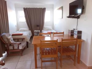 sala de estar con mesa y cama en Come Home in Oudtshoorn Self-Catering Units, en Oudtshoorn