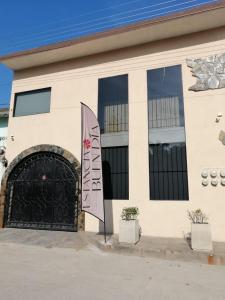 un edificio con una puerta negra y una bandera en Estancia Buen Dia, en Ciudad Valles
