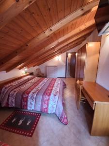 ein großes Bett in einem Zimmer mit Holzdecke in der Unterkunft B&B Piazzi di Katia in Caderzone