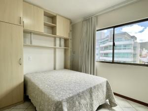 1 dormitorio con cama y ventana grande en 205 - Apartamento 02 dormitórios apenas 50m praia de Bombas, en Bombinhas