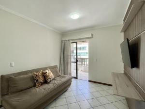 sala de estar con sofá y TV en 205 - Apartamento 02 dormitórios apenas 50m praia de Bombas, en Bombinhas