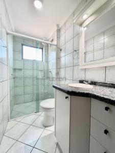 y baño con ducha, aseo y lavamanos. en 205 - Apartamento 02 dormitórios apenas 50m praia de Bombas, en Bombinhas