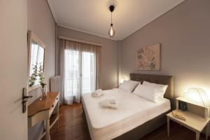 sypialnia z dużym białym łóżkiem i biurkiem w obiekcie Spacious 3 Bedroom apt near Acropolis museum w Atenach