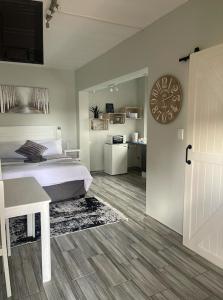 een slaapkamer met een bed en een klok aan de muur bij 22 on Mirabel in Kempton Park