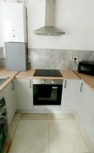 a kitchen with white cabinets and a black microwave at 8 Guest Lovely home in Liverpool in Liverpool