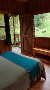 a bedroom with a bed and a door with animals in the field at Finca Terra Viva in Monteverde Costa Rica