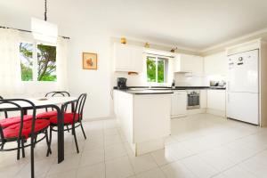 una cucina con elettrodomestici bianchi e tavolo con sedie di BeOnHolidays Villa Berry a Santa Ponsa