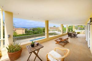 a living room with a balcony with chairs and tables at BeOnHolidays Villa Berry in Santa Ponsa