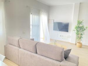 a living room with a couch and a tv at HomeForGuest Two bedroom Apartment with pool and terrace in Caleta De Fuste