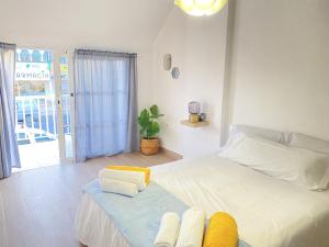 a bedroom with a large white bed with towels on it at HomeForGuest Two bedroom Apartment with pool and terrace in Caleta De Fuste