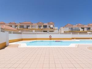 a large swimming pool in front of some buildings at HomeForGuest Two bedroom Apartment with pool and terrace in Caleta De Fuste