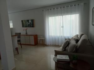 a living room with a couch and a window at Casa Capitolio in Capitólio