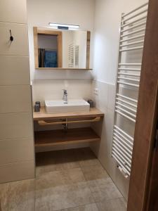 ein Bad mit einem Waschbecken und einem Spiegel in der Unterkunft Saumerhof in Schladming