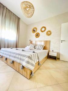 a bedroom with a large bed and a chandelier at Superbe Appartement avec Piscine - 5 min de la Plage à Imi Ouaddar in Imi Ouaddar