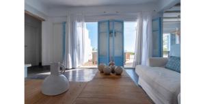 ピソ・リバディにあるMorfia Villasのリビングルーム(白いソファ、青いドア付)