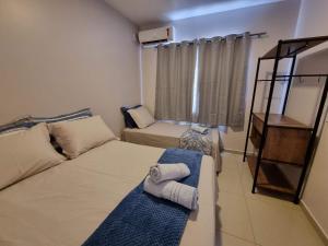 a small room with two beds and a window at Curta Praia de Armação - Casa Violeta in Penha