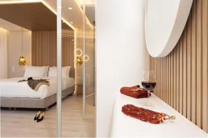 a bedroom with a bed and a wine glass at LUX&EASY Acropolis Suites in Athens