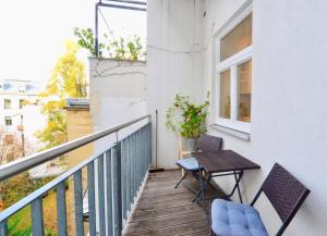 a balcony with two chairs and a table and a window at Beautiful Flat Next to Karlskirche in Vienna