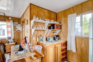 una cucina con pareti in legno, lavandino e tavolo di Gavra Cabana at Bella Vue Estate a Georgeville