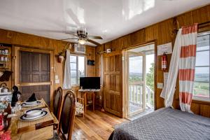 um quarto com uma cama, uma mesa e uma televisão em Gavra Cabana at Bella Vue Estate em Georgeville