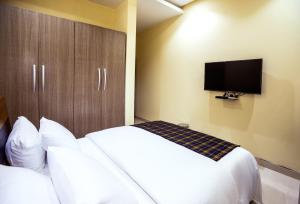 a hotel room with two beds and a flat screen tv at Rushmore - Standard Room in Lagos