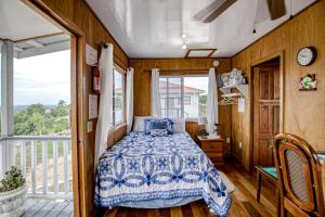 um quarto com uma cama e uma varanda em Jehane Cabana at Bella Vue Estate em Georgeville