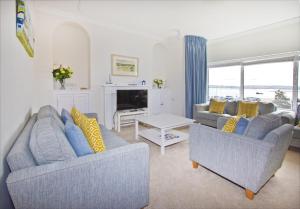 uma sala de estar com dois sofás e uma mesa em Beautiful Aberdovey Seafront Apartment 2 em Aberdyfi