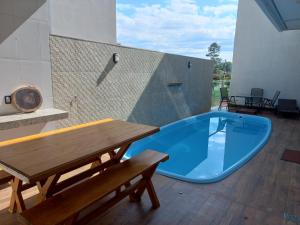 eine große blaue Badewanne auf einer Terrasse mit einem Holztisch in der Unterkunft Casa Capitolio in Capitólio