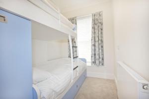 a bedroom with bunk beds and a window at Beautiful Aberdovey Seafront Apartment 2 in Aberdyfi