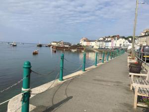 a dock with a chain and boats in the water at Beautiful Aberdovey Seafront Apartment 2 in Aberdyfi