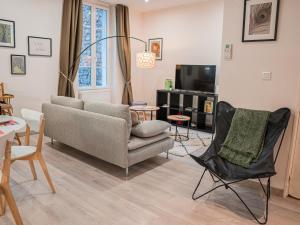 a living room with a couch and a chair at L'annexe Clermont Ferrand in Clermont-Ferrand