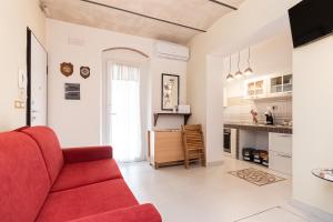 a living room with a red couch and a kitchen at Lerici Natural Suite in Lerici