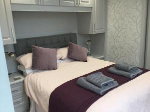 un letto con due cuscini sopra di Leafy Lytham central Lovely ground floor 1 bedroom apartment with private garden In Lytham dog friendly a Lytham St Annes