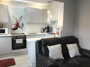 a living room with a couch and a kitchen at Leafy Lytham central Lovely ground floor 1 bedroom apartment with private garden In Lytham dog friendly in Lytham St Annes