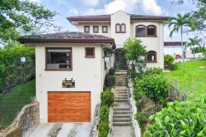 a white house with a wooden garage at Casa Gerónimo in Playa Hermosa