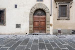 a wooden door on a building with a stone floor at Le Grazie Luxury Apartment in Florence