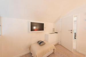 een witte kamer met een bed en een tv aan de muur bij Le Grazie Luxury Apartment in Florence