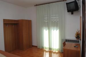 salon z telewizorem i zasłoną w obiekcie Albergo "da Mario" w mieście Pianoro