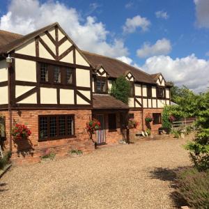 an old house with a stone driveway in front of it at NIGHTINGALE B&B in Pershore