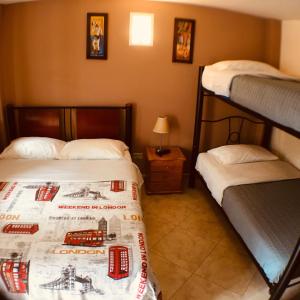 1 Schlafzimmer mit 2 Etagenbetten und einem Tisch mit einer Lampe in der Unterkunft Hostal La Candelaria in Bogotá